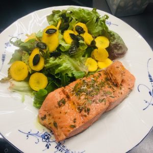 Wild Salmon from Alaska with yellow carrots and salad.